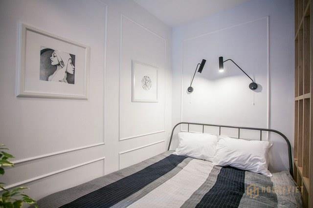 Góc nghỉ ngơi khá đơn giản và tiện dụng với hệ kệ gỗ ngay hông giường ngủ. Trên tường được trang trí bằng những bức chân dung đẹp mắt